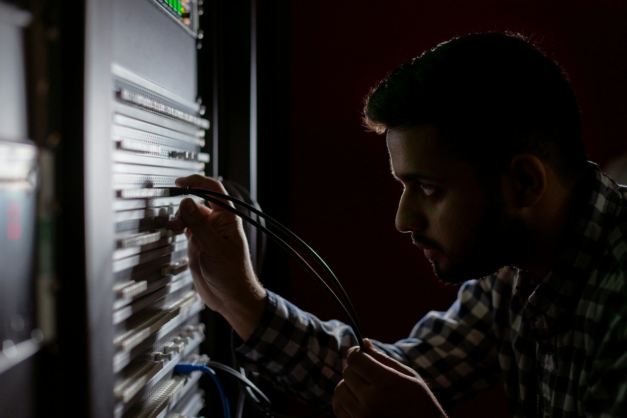 Technician patching cables into a network switch